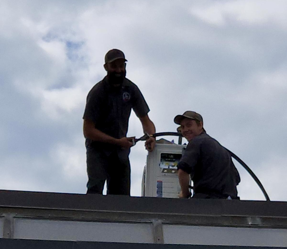 Seer Heating & Refrigeration technicians servicing a rooftop unit